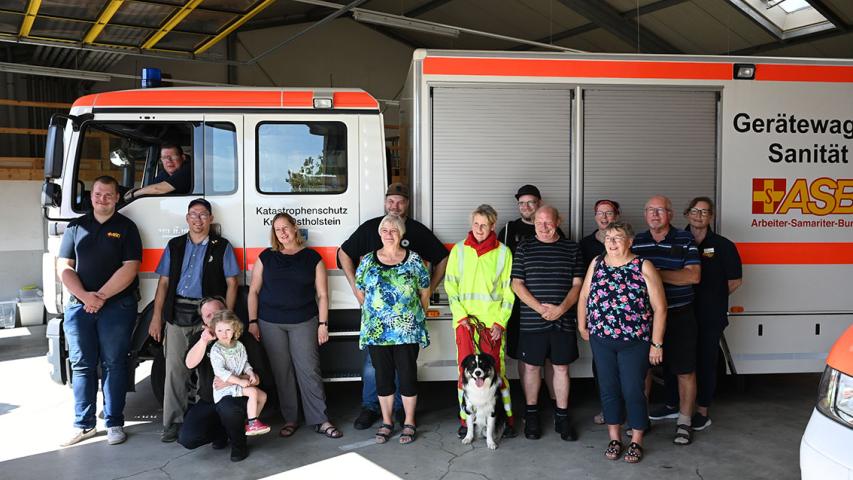 Dänisch-deutsches Ehrenamt vor dem Gerätewagen Sanität.